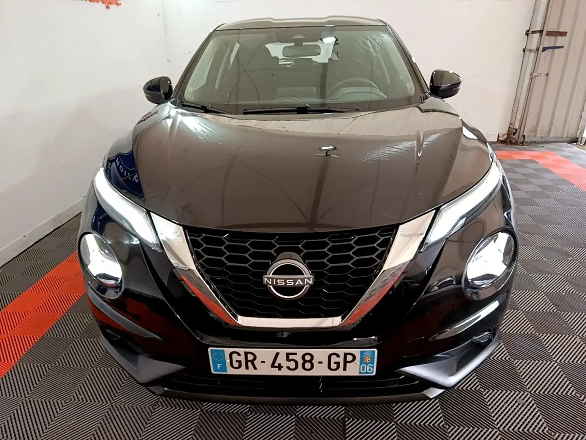 Vue avant d'un Nissan Juke noir 2023 avec calandre en nid d'abeille et phares LED ellipsoïdaux visibles.