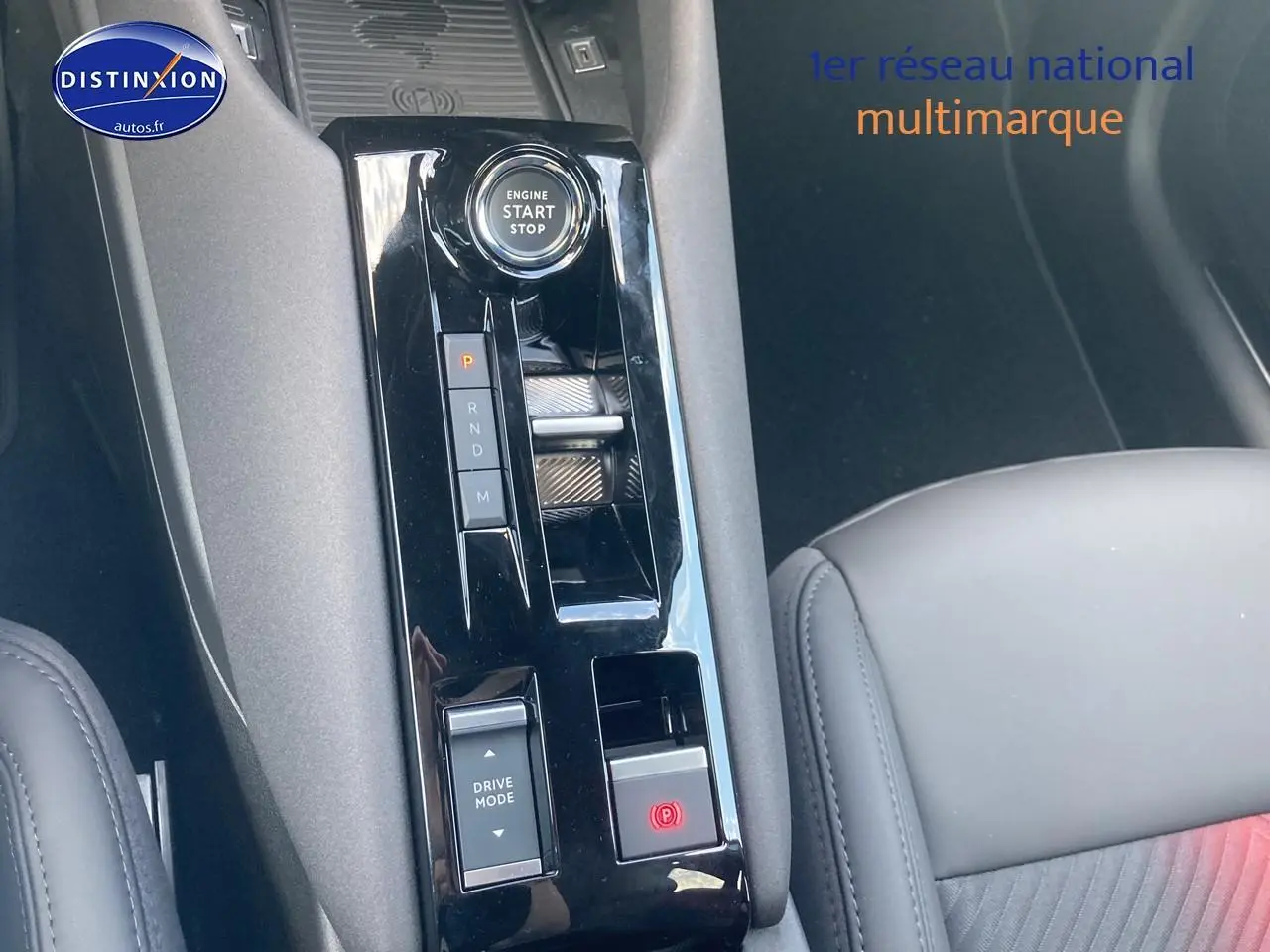 Vue rapprochée de la console centrale noire de l'Alfa Romeo Junior 1.2 hybride 2026 avec bouton start/stop et commande boîte auto.
