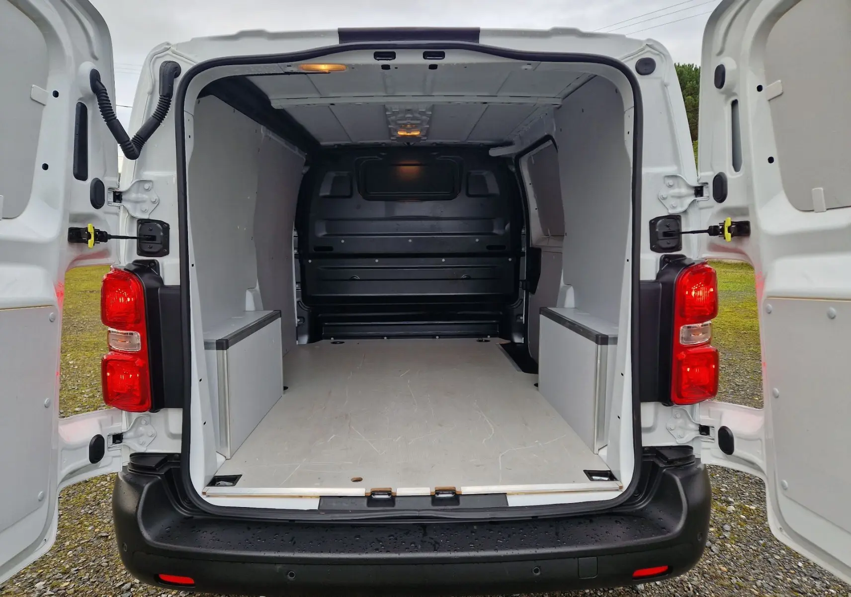 Vue arrière du FIAT Scudo Fourgon blanc 2024 avec portes ouvertes, espace de chargement vide et éclairage intérieur allumé.