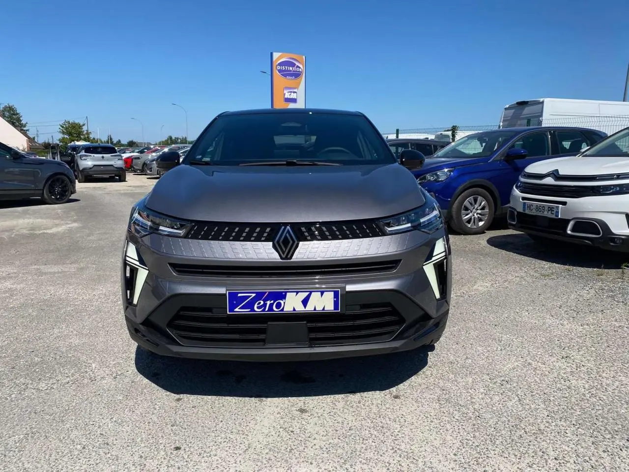 Vue de face du Renault Captur 2025 gris Cassiopée avec toit noir, affichant sa calandre distinctive et ses phares LED fins.