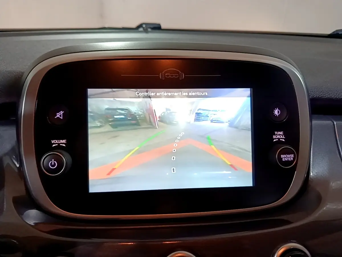 Écran tactile central de la Fiat 500X gris foncé montrant la caméra de recul avec guidage dynamique.