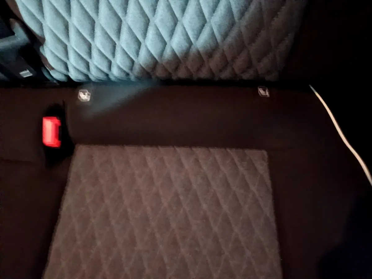 Vue rapprochée de la banquette arrière gris foncé matelassée du Fiat 500X 2019 avec ceinture rouge visible.