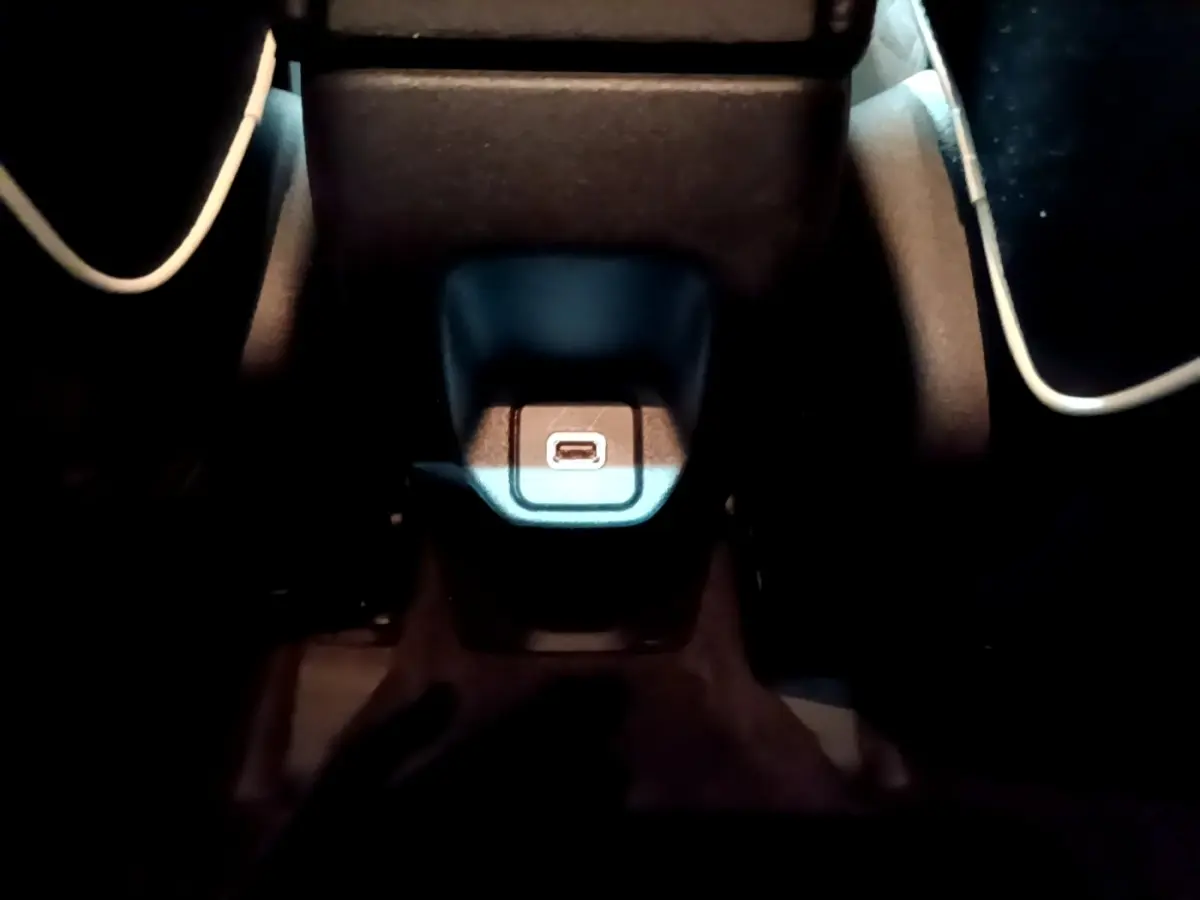 Gros plan sur la prise USB centrale éclairée dans l'habitacle sombre d'une Fiat 500X gris foncé.