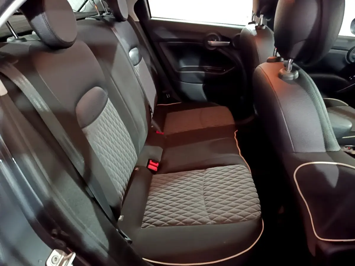Vue intérieure côté gauche montrant la banquette arrière gris foncé avec surpiqûres et appuie-têtes du Fiat 500X.