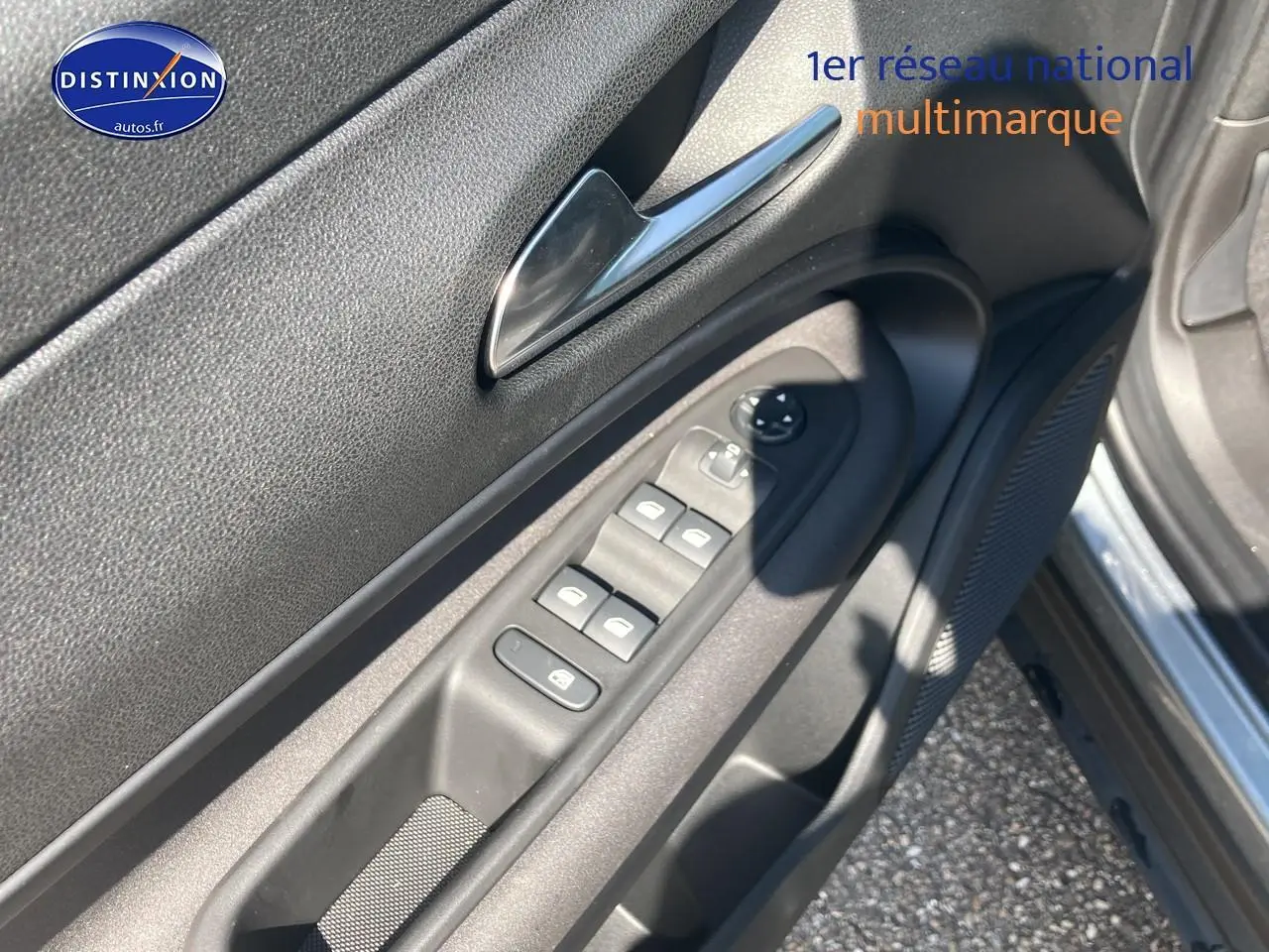 Vue rapprochée de la porte conducteur d'une Alfa Romeo Junior 1.2 hybride gris t/noir, montrant les commandes des vitres et rétroviseurs.