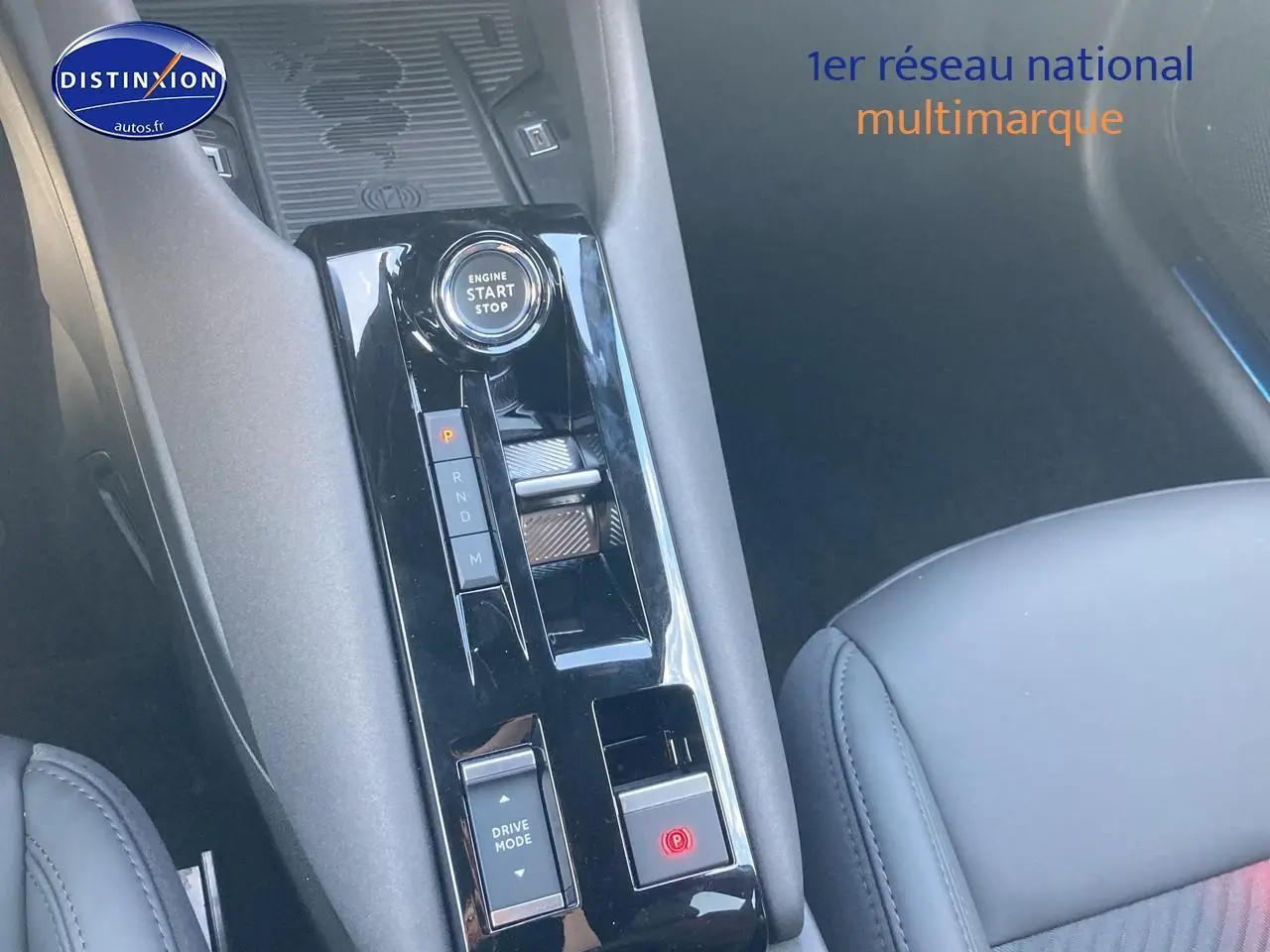Gros plan sur la console centrale noire brillante de l'Alfa Romeo Junior 1.2 hybride avec bouton start/stop et commandes de boîte auto.