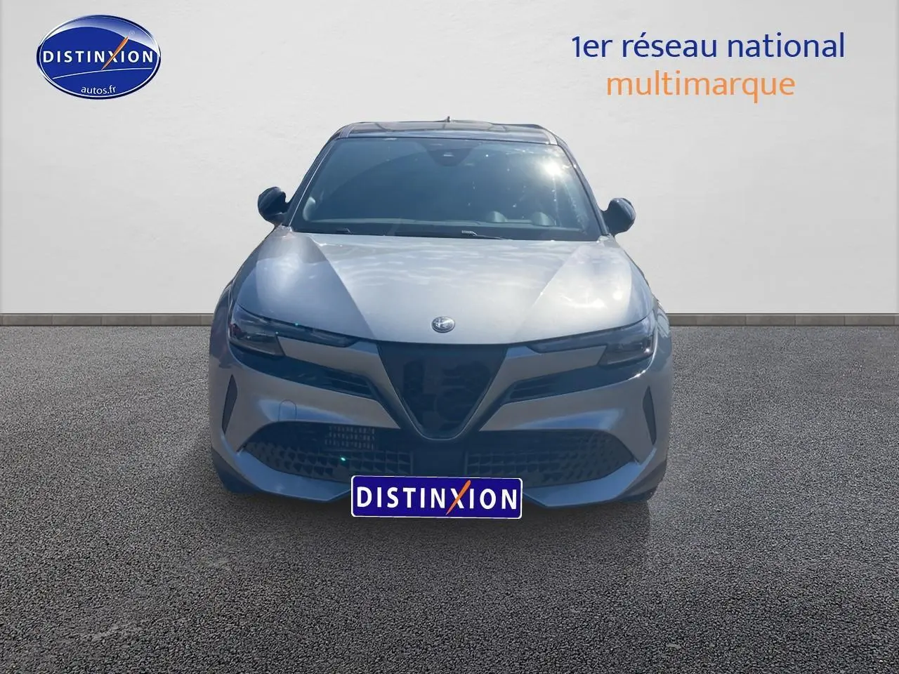 Vue frontale d'une Alfa Romeo Junior 1.2 hybride gris t/noir avec calandre caractéristique et phares LED matrix.