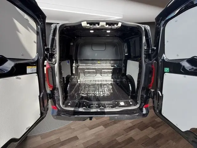 Vue arrière ouverte du Volkswagen Transporter noir 2026 montrant la zone de chargement vide et les portes battantes ouvertes.