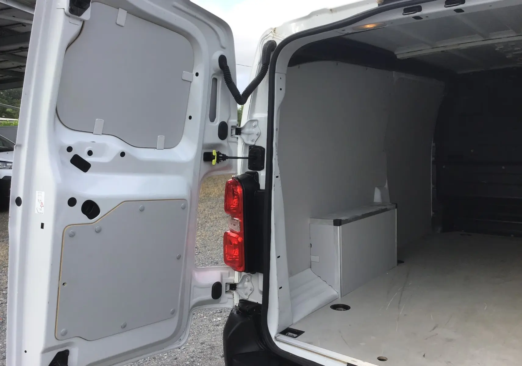 Vue arrière intérieure du FIAT Scudo Fourgon blanc 2024, portes ouvertes montrant l’espace de chargement vide avec cloison partielle.