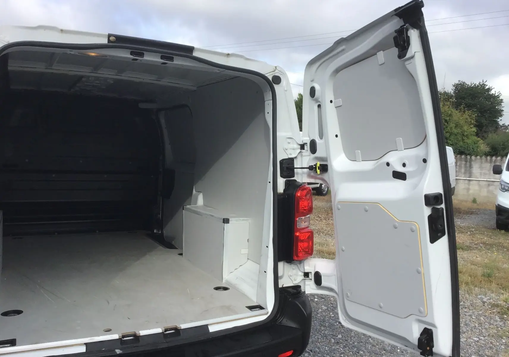 Vue arrière ouverte du FIAT Scudo Fourgon blanc 2024, montrant l’espace de chargement vide et la porte droite ouverte.