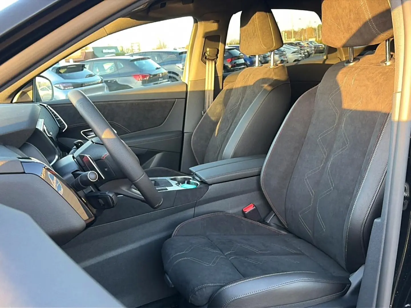 Vue intérieure côté conducteur du DS7 1.5 BlueHDi 130 noir, sièges en cuir et alcantara avec surpiqûres contrastées.
