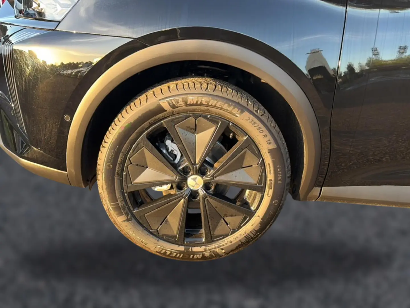 Gros plan sur la roue avant gauche noire du DS7 1.5 BlueHDi 130 avec jante alu au design géométrique.
