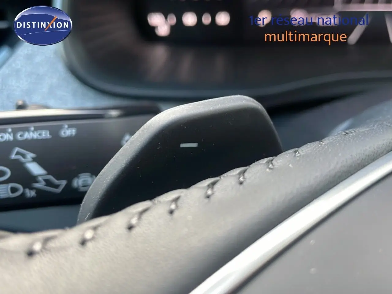 Gros plan sur la palette de changement de vitesse au volant d’un Skoda Kamiq gris argent, intérieur cuir noir.