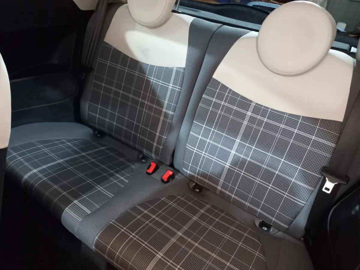 Vue rapprochée de la banquette arrière à motif écossais gris et beige de la Fiat 500 Lounge noire de 2018.