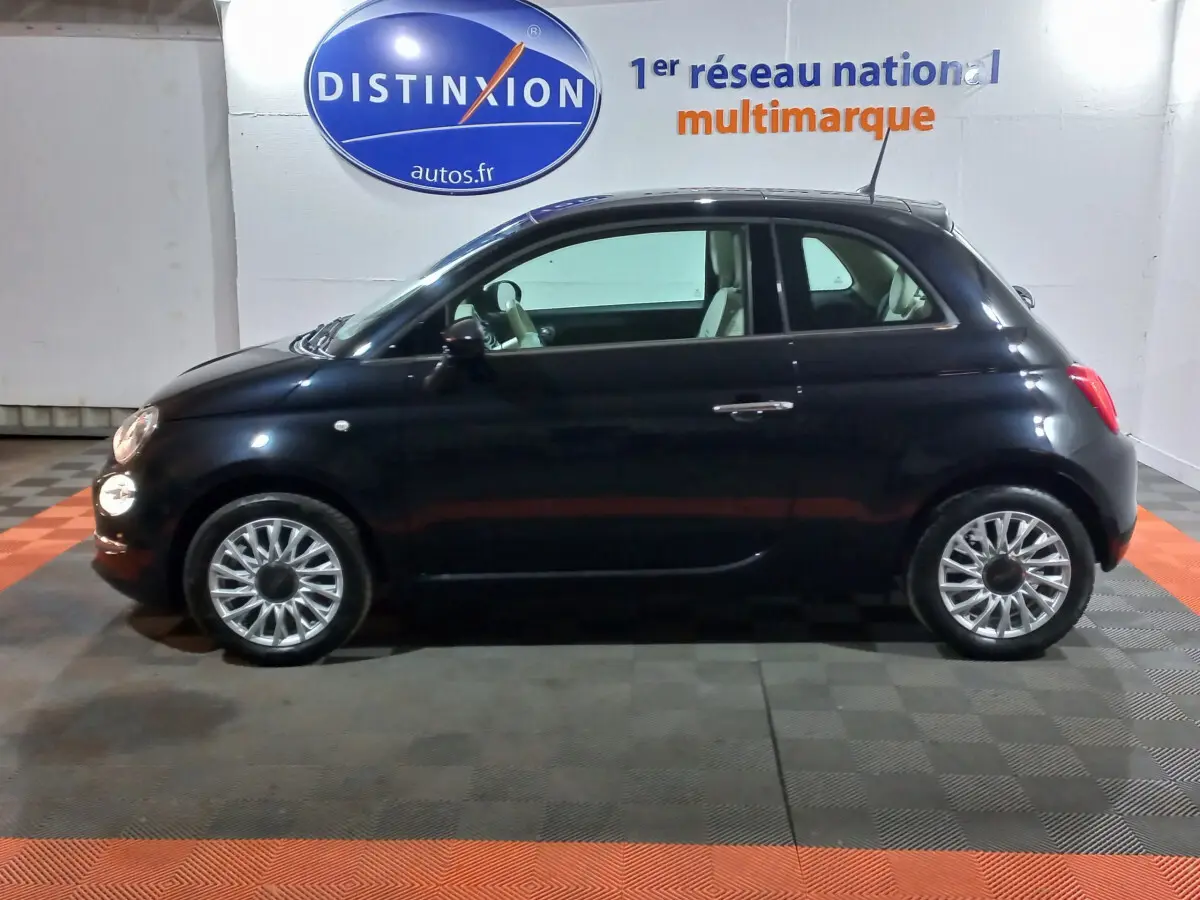 Profil côté gauche de la Fiat 500 noire de 2018, finition Lounge, avec jantes alliage et intérieur clair visible.