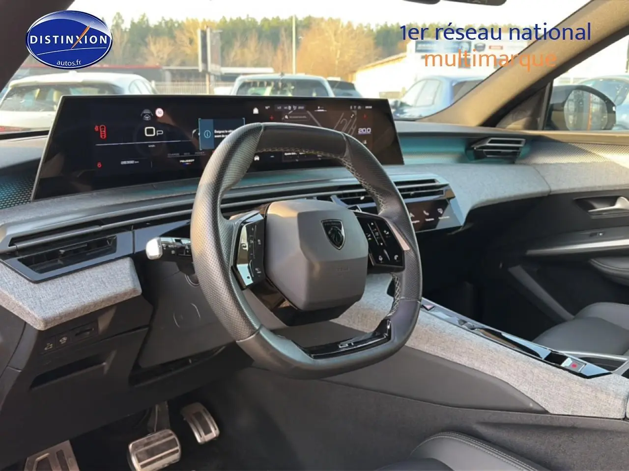 Intérieur avant du Peugeot 3008 gris 2025, volant cuir multifonction et grand écran tactile panoramique.