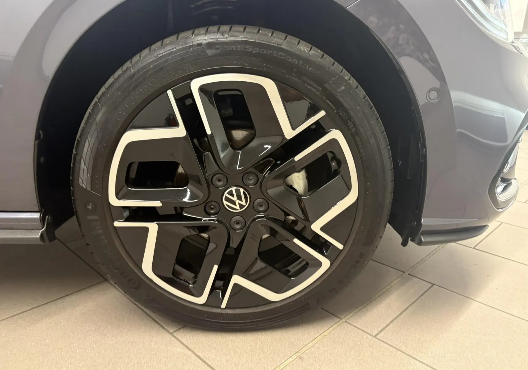 Gros plan sur la jante avant droite noire et argentée d'une Volkswagen Polo gris cendré 2025 finition R-Line.