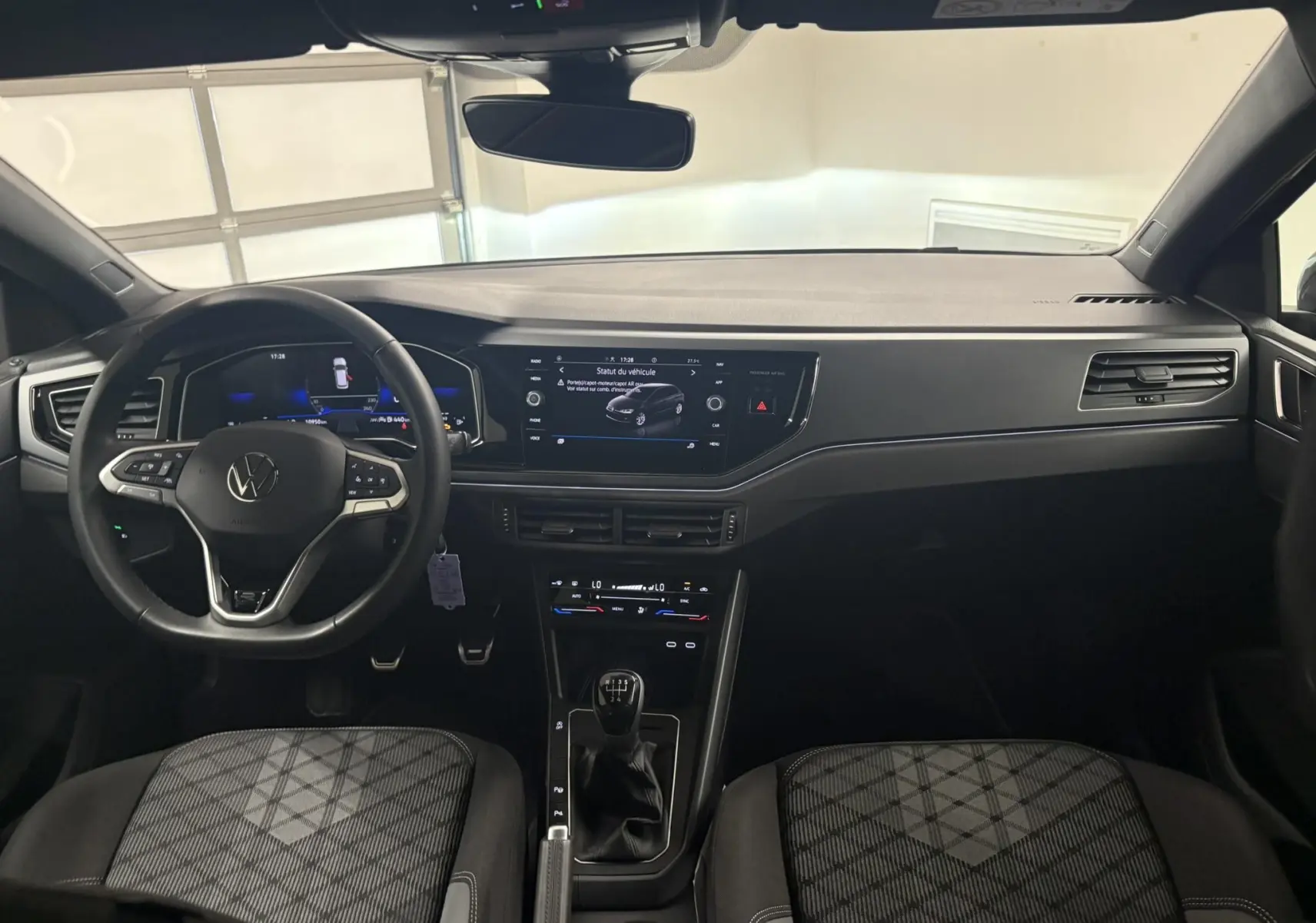Vue intérieure avant du Volkswagen Polo 1.0 TSI R-Line 2025, tableau de bord moderne et volant multifonction noir.