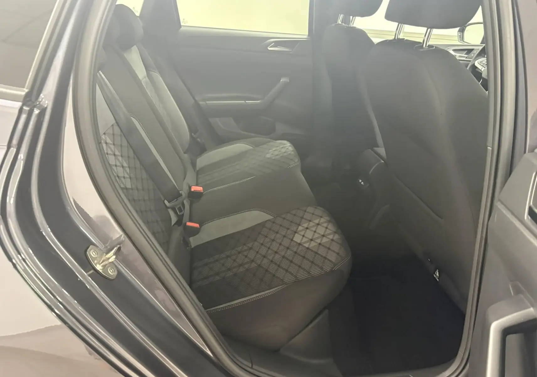 Vue intérieure côté gauche des sièges arrière de la Volkswagen Polo gris cendré avec sellerie tissu à motifs géométriques.