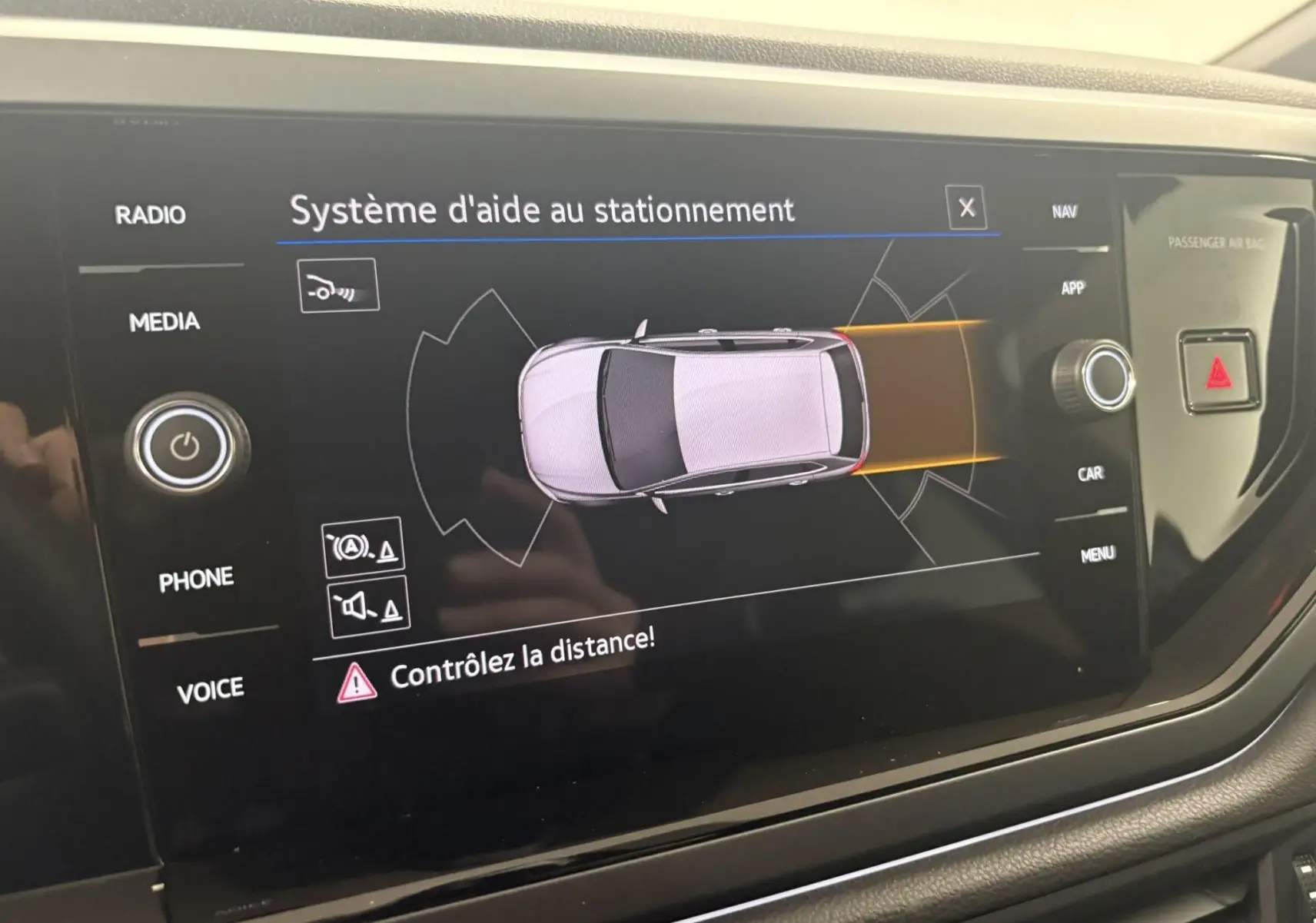 Écran du système d'aide au stationnement de la Volkswagen Polo 1.0 TSI R-Line, affichant une vue aérienne du véhicule gris cendré.
