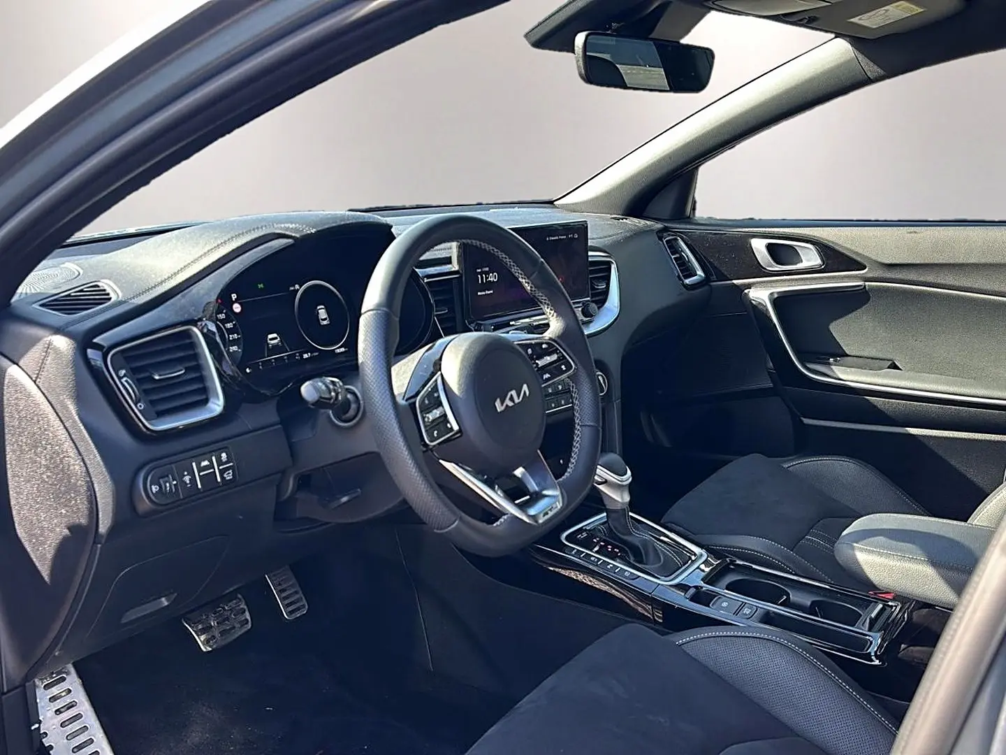Intérieur avant du KIA Xceed gris 2024, vue côté conducteur, volant cuir multifonction et console centrale brillante.