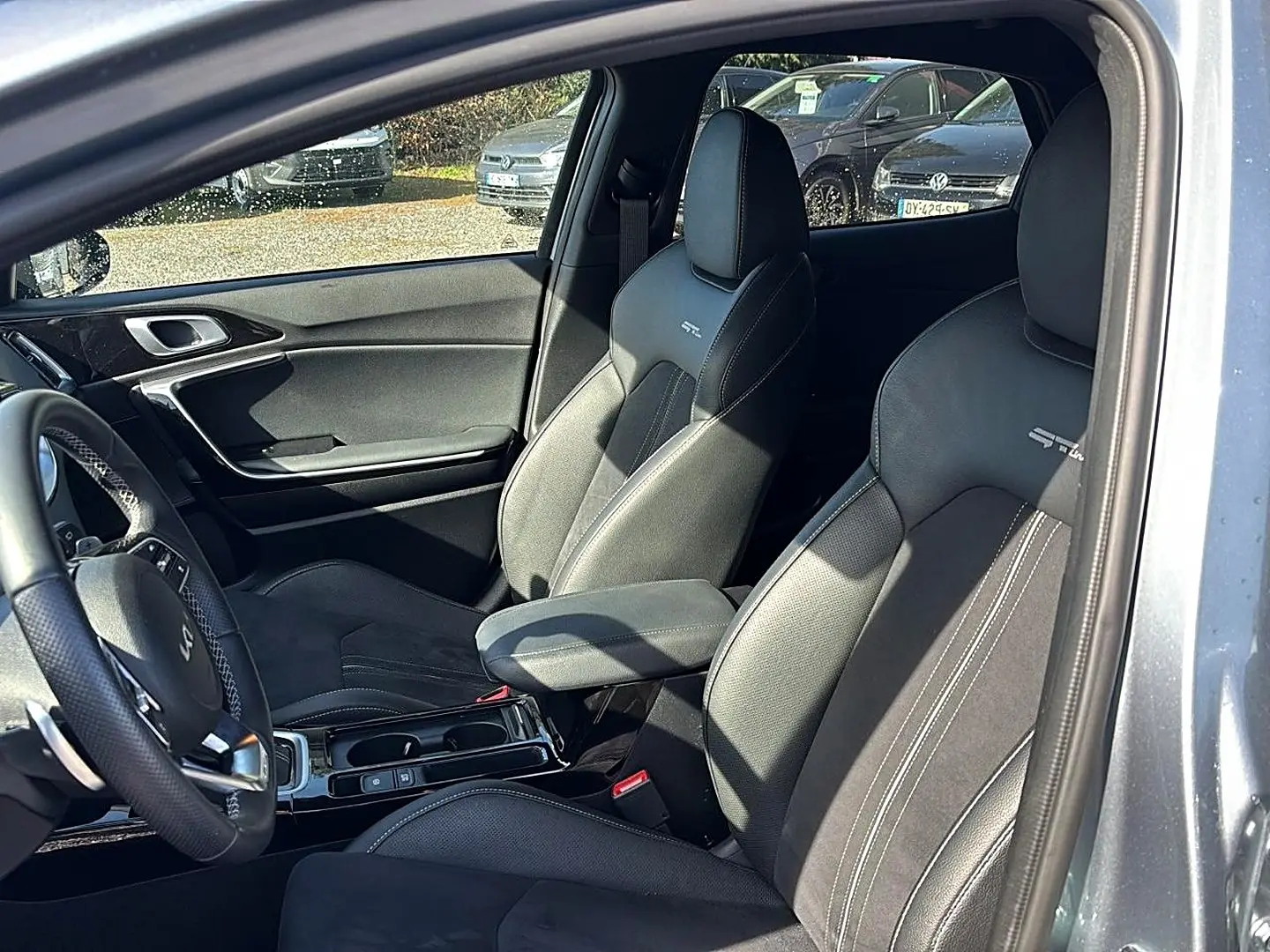 Vue intérieure côté conducteur du Kia Xceed gris 2024, sièges sport GT-Line en cuir avec accoudoir central.