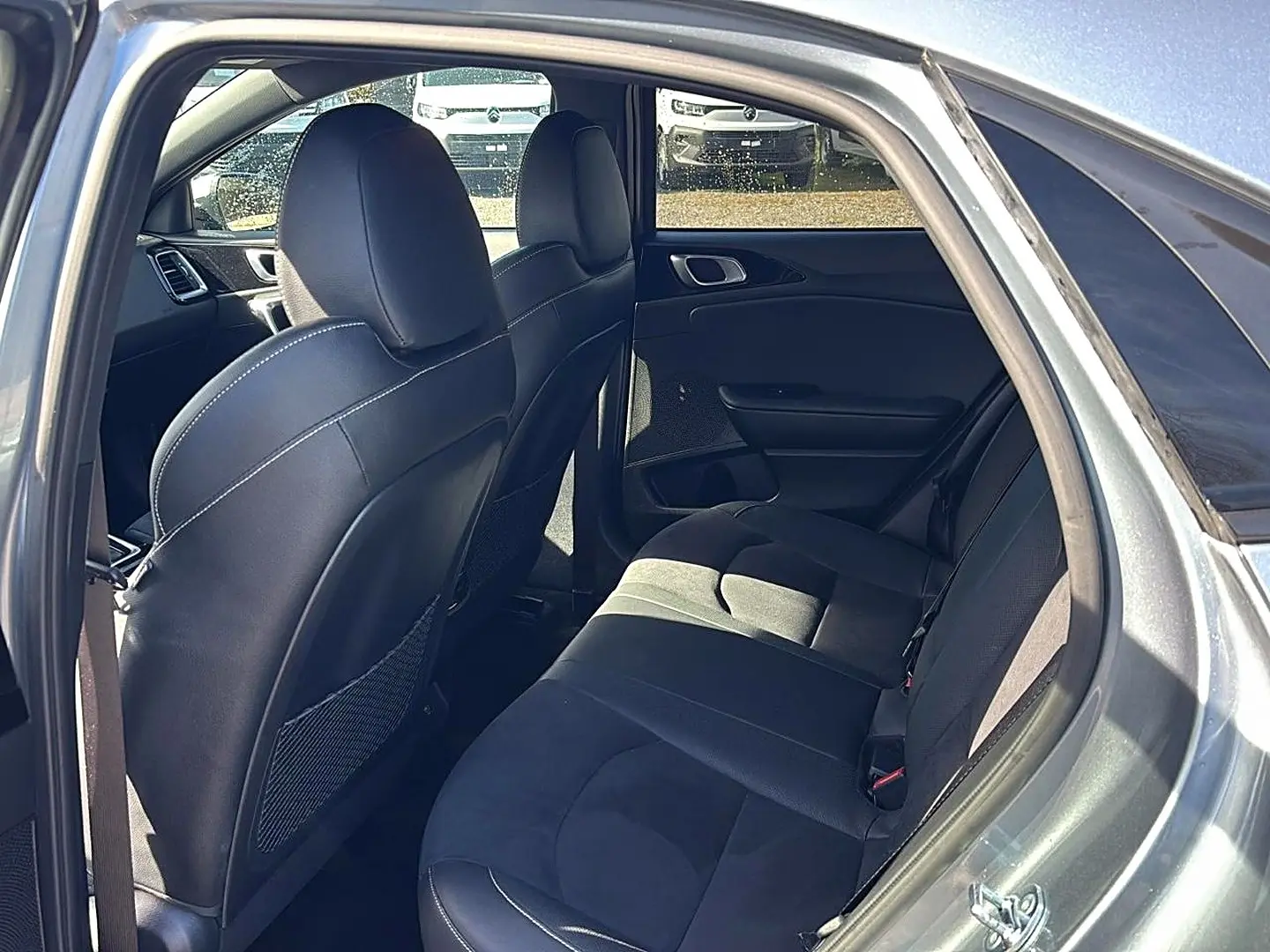 Vue intérieure côté droit arrière du Kia Xceed gris 2024, montrant les sièges en tissu et cuir avec appuie-têtes.