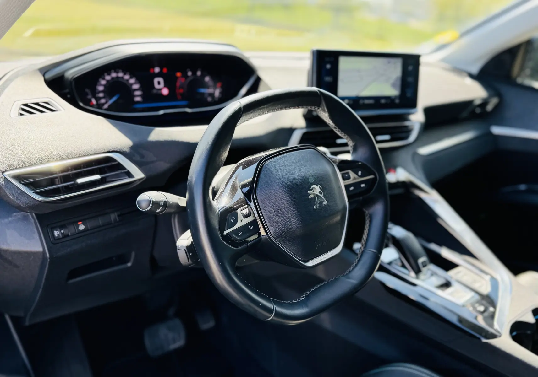 Intérieur du Peugeot 3008 gris Artens, vue du poste de conduite avec volant compact et écran tactile central.
