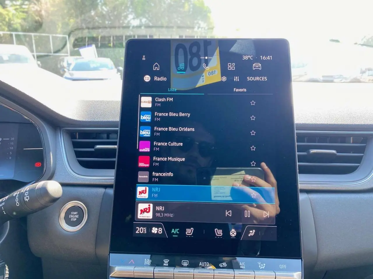 Écran tactile central du tableau de bord du Renault Captur gris Rafale, affichant les stations radio FM avec commandes tactiles.