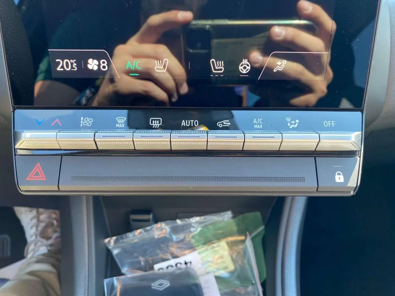 Gros plan sur la console centrale tactile du Renault Captur 2025 avec commandes climatisation et boutons argentés.