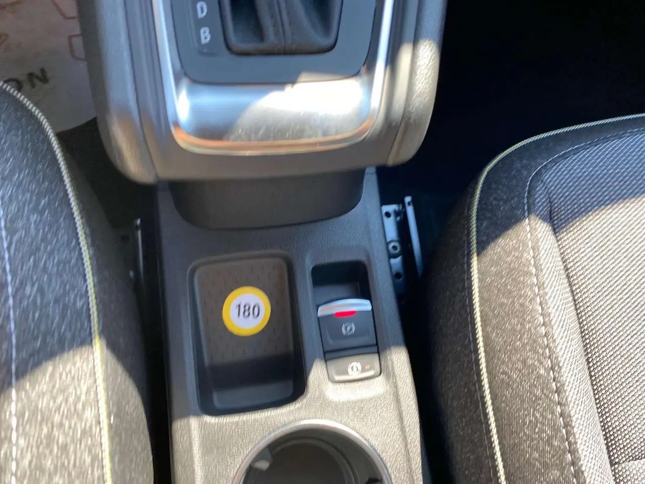 Gros plan sur la console centrale du Renault Captur 2025 avec levier de boîte auto et sièges tissu gris.