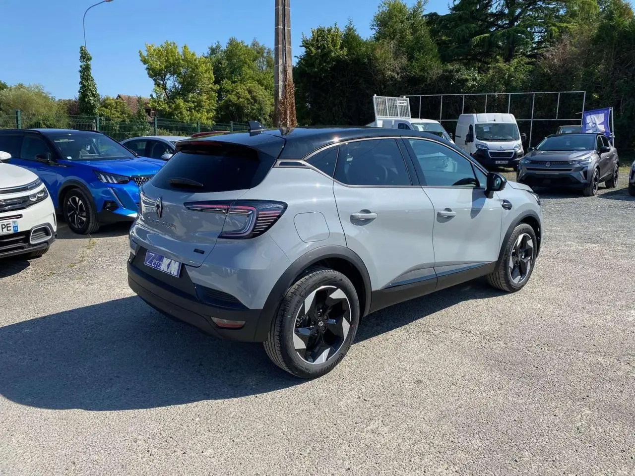Renault Captur 2025 gris Rafale avec toit noir, vue 3/4 arrière côté droit, jantes noires distinctives.