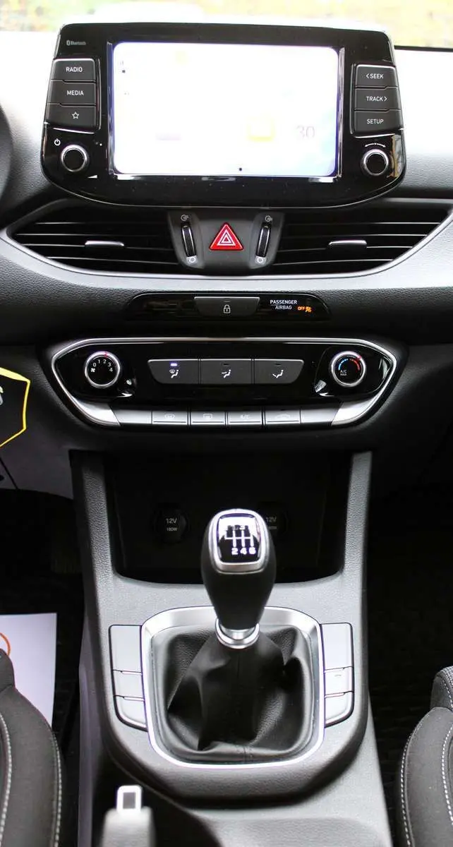 Vue rapprochée de la console centrale de la Hyundai i30 SW 2024 avec boîte manuelle et écran tactile lumineux.