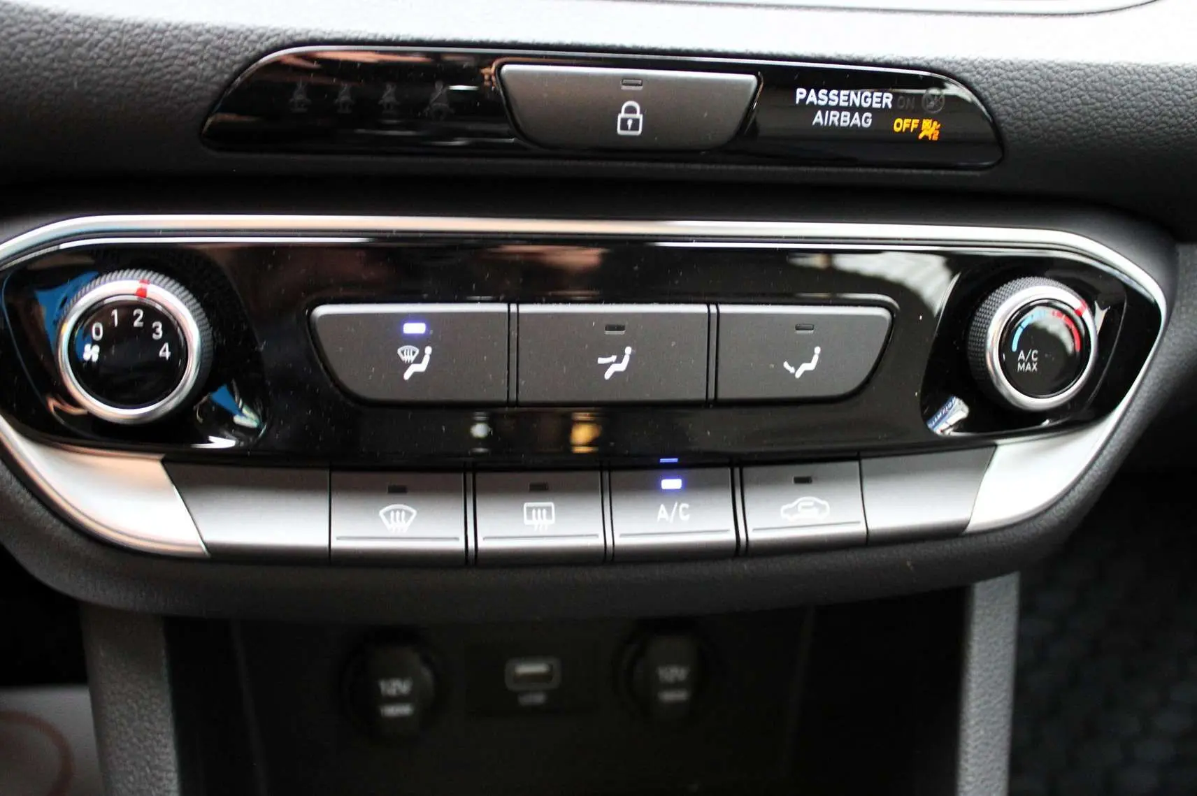 Panneau de commande de climatisation de la Hyundai i30 SW 2024, avec boutons éclairés et finition noire brillante.