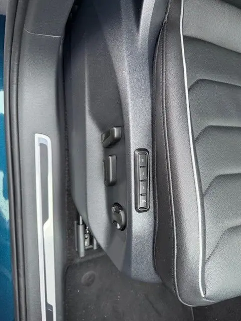 Vue rapprochée des commandes électriques du siège conducteur en cuir noir du Volkswagen Tiguan Night Shade Blue 2022.