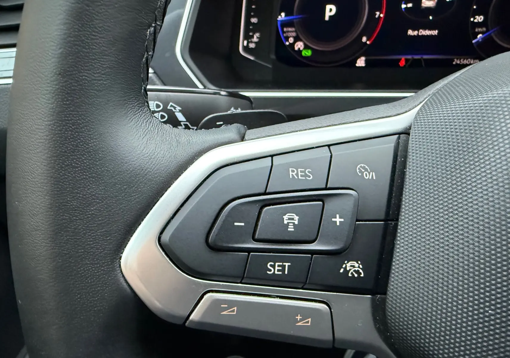 Gros plan sur les commandes au volant du Volkswagen Tiguan 2022, avec boutons de régulateur de vitesse et assistance conduite.