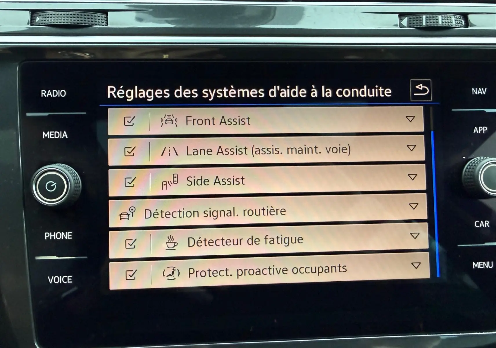 Écran tactile intérieur affichant les réglages des aides à la conduite du Volkswagen Tiguan 2022 en vue frontale.