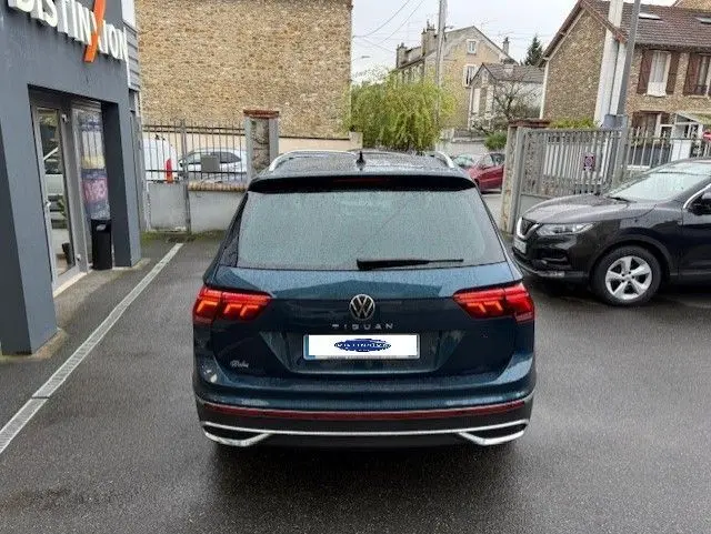 Vue arrière d'un Volkswagen Tiguan 2022 bleu nuit avec feux LED et double sortie d'échappement chromée.