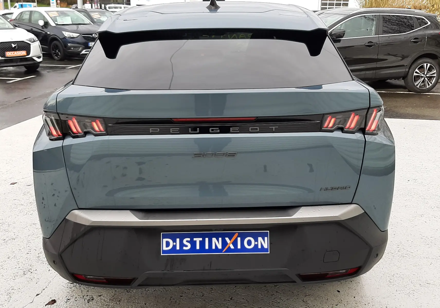 Vue arrière d'un Peugeot 3008 III Hybrid 145 Allure en bleu Ingaro avec feux LED caractéristiques et vitre arrière teintée.