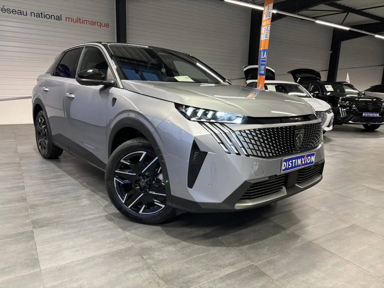 Peugeot 3008 gris Artense en 3/4 avant droit, calandre noire à motif géométrique et jantes alliage noires.