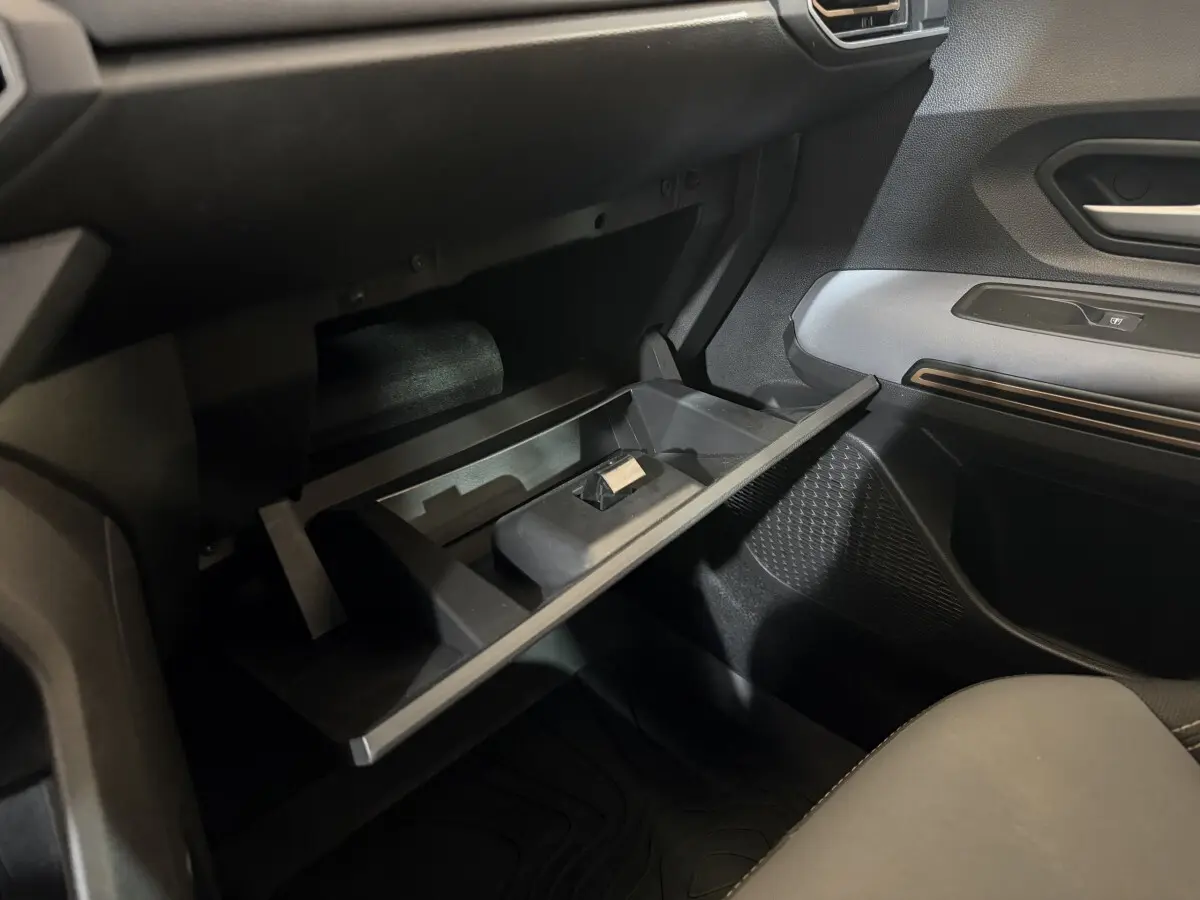 Vue intérieure côté passager du coffre à gants ouvert de la Dacia Sandero Extreme+ TCe 110 2024, avec détails en noir et gris.