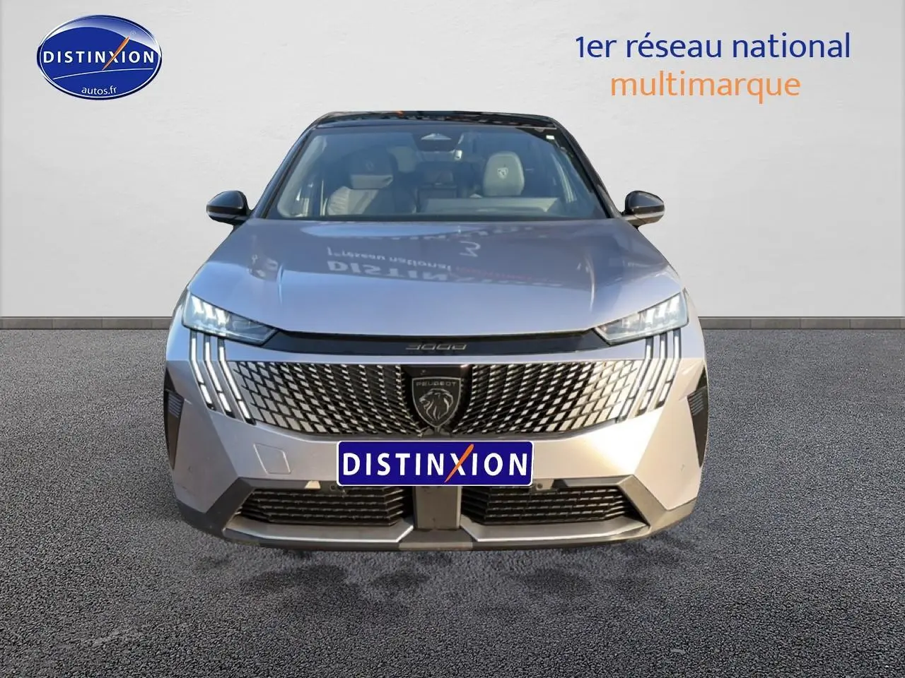 Vue frontale d’un Peugeot 3008 gris 2025 avec calandre distinctive et phares LED en forme de griffes.