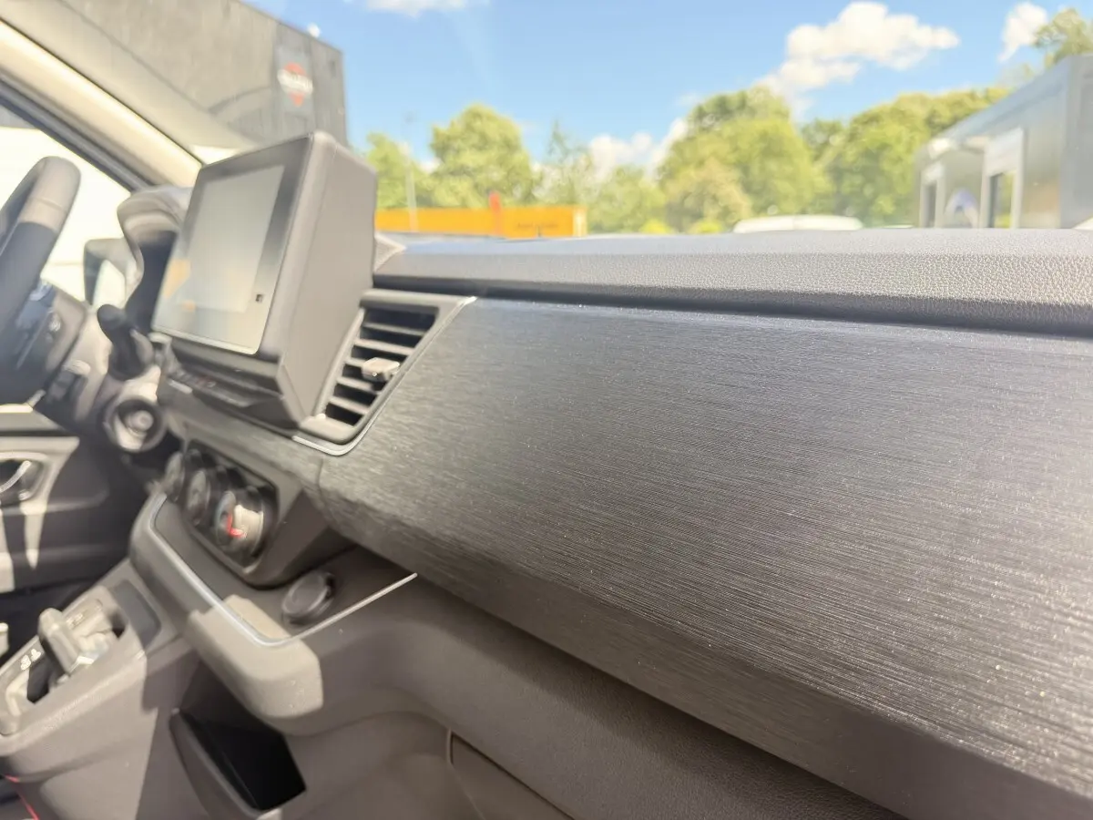 Vue intérieure côté passager du tableau de bord noir texturé du Renault Trafic Fourgon blanc 2025.