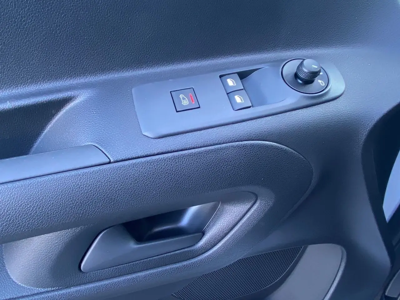 Gros plan sur la commande de vitres et rétroviseurs côté conducteur du Peugeot Partner blanc 2024.