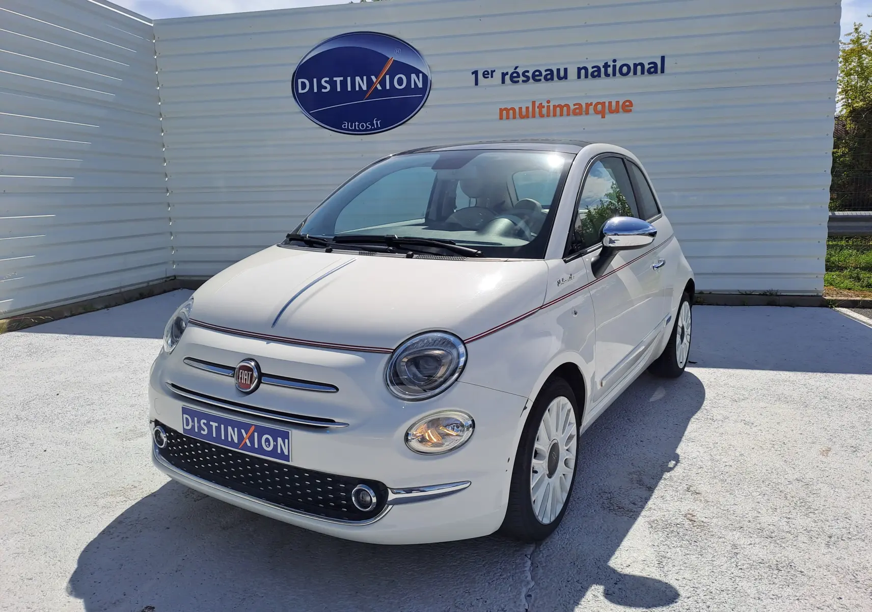 Fiat 500 blanc vue 3/4 avant droit, avec jantes blanches et détails chromés sur les rétroviseurs.