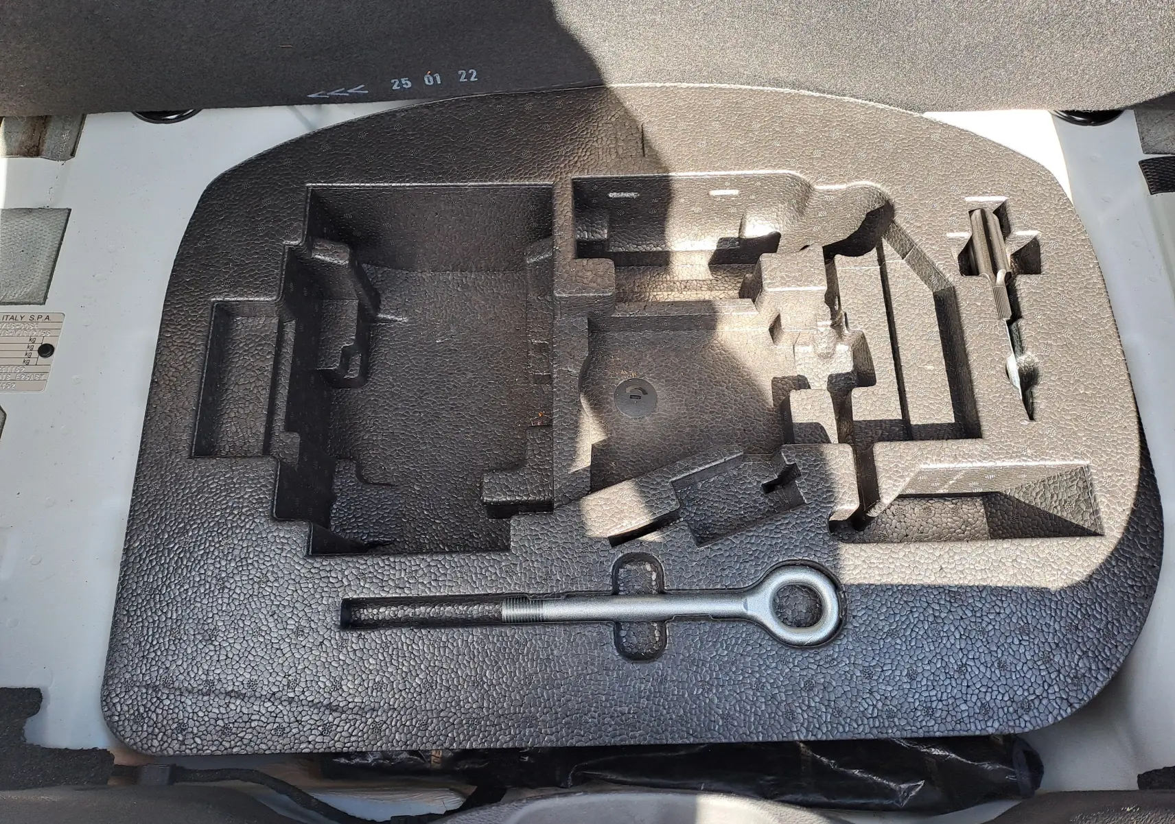 Coffrage en mousse noire pour outils de bord sous le coffre d'une Fiat 500 blanche 2022, version hybride.