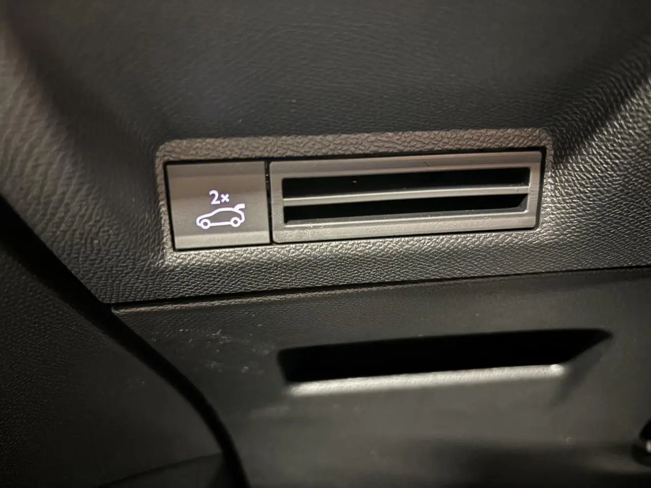 Bouton d'ouverture du hayon et prise d'air noire dans l'habitacle du Peugeot 3008 gris Artense.