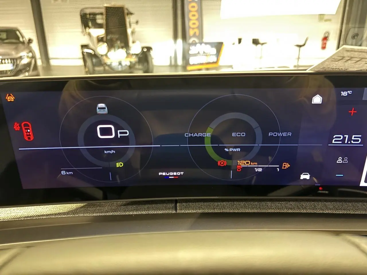 Vue rapprochée du tableau de bord numérique du Peugeot 3008 gris Artense, affichant les indicateurs de charge et vitesse.