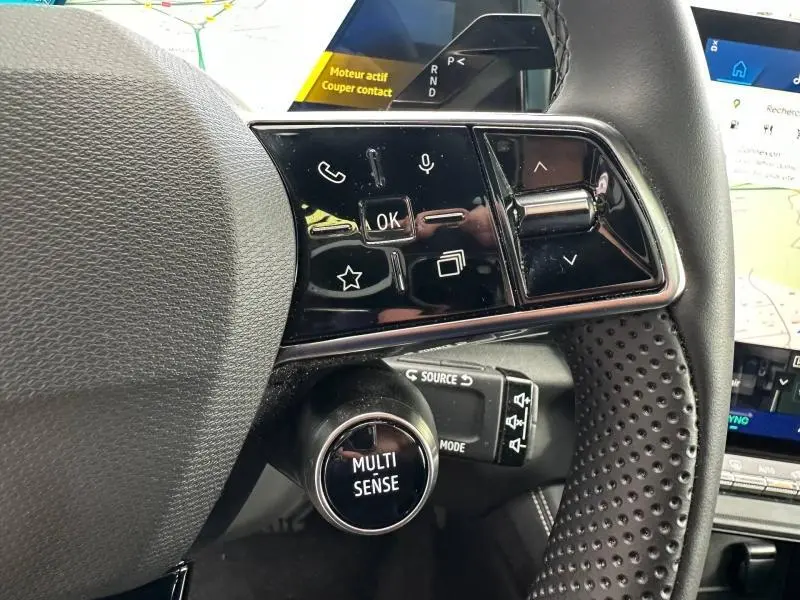 Gros plan sur le volant côté gauche du Renault Austral 2025, avec commandes multifonctions et bouton "MULTI SENSE".