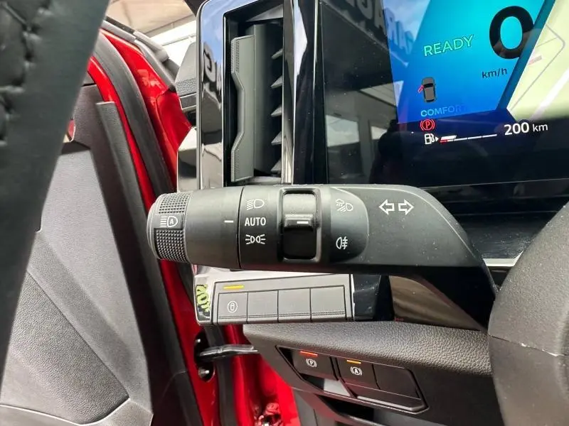 Détail intérieur du commodo gauche et tableau de bord numérique du Renault Austral Rouge Flamme, version hybride 2025.